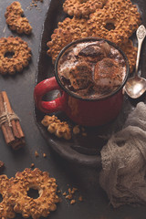 Hot chocolate in a red mug, cookies with nuts. Cozy atmosphere, Toned photo. Selective focus