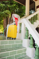 straw hat and a yellow bag on the steps of the house