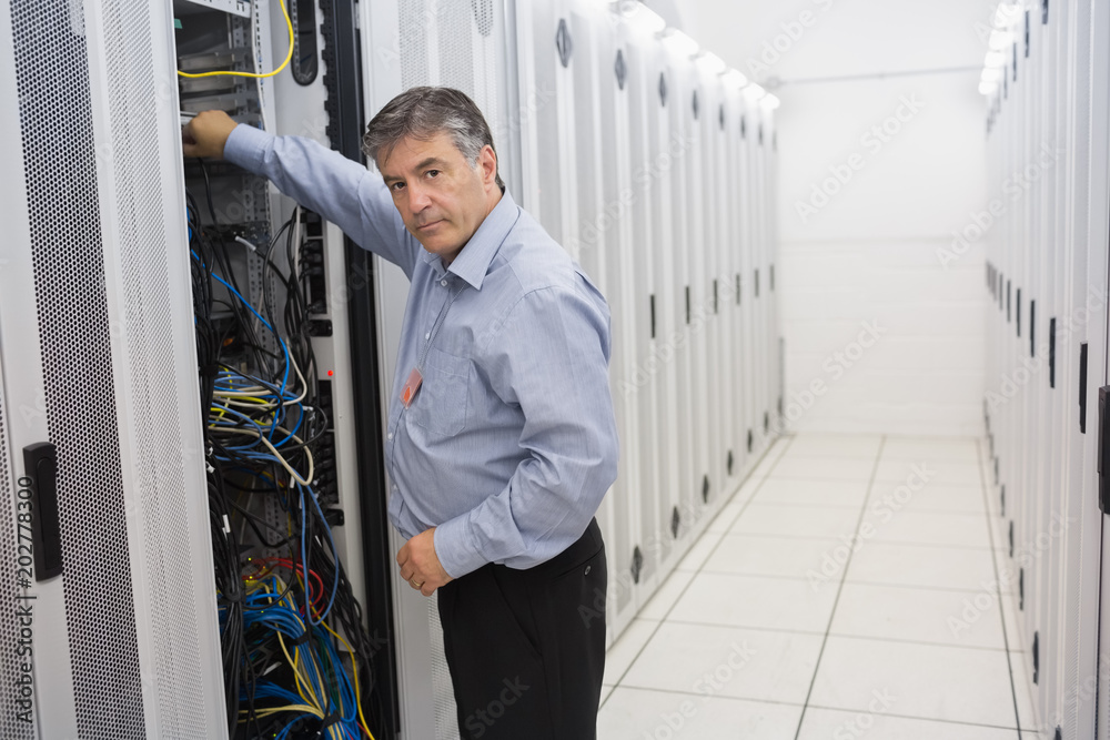 Poster man fixing wires of servers