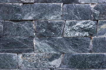 The wall is made of granite stone. Background.