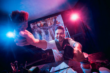 The young artist at work in the studio. Canvas on the background