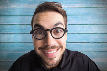 Portrait of a smiling businessman with glasses against wooden planks