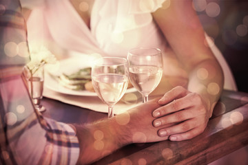 Couple holding hands at dinner at home in the dining room