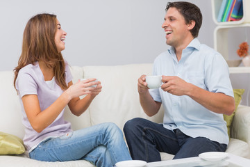 Cheerful couple enjoying their tea at home