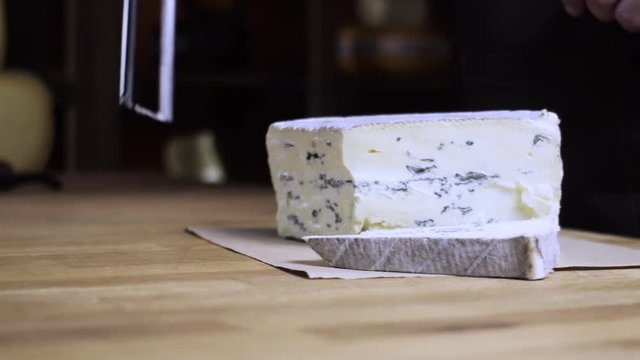 Blue cheese is cut into a string. Cheese shop. 4k