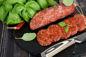 Delicious salami with basil , selective focus
