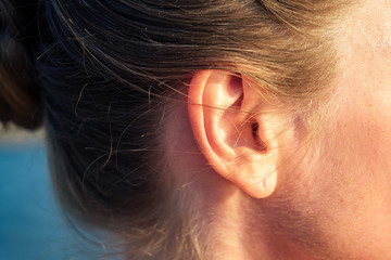 ear of a happy woman with a beautiful earring - obrazy, fototapety, plakaty