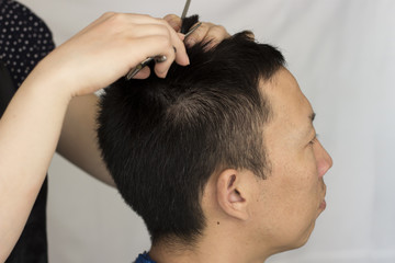 Obraz na płótnie Canvas Hairdresser cuts a man, close-up