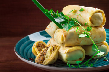 Pancakes stuffed with liver. Wooden rustic background. Top view