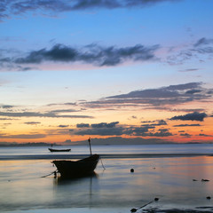Naklejka na ściany i meble Fishing boat in the sea at sunrise