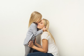 Happy mother and daughter embracing at studio