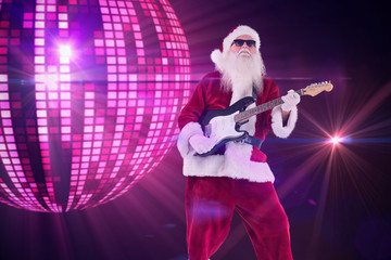 Fototapeta premium Santa Claus plays guitar with sunglasses against digitally generated cool disco ball design 