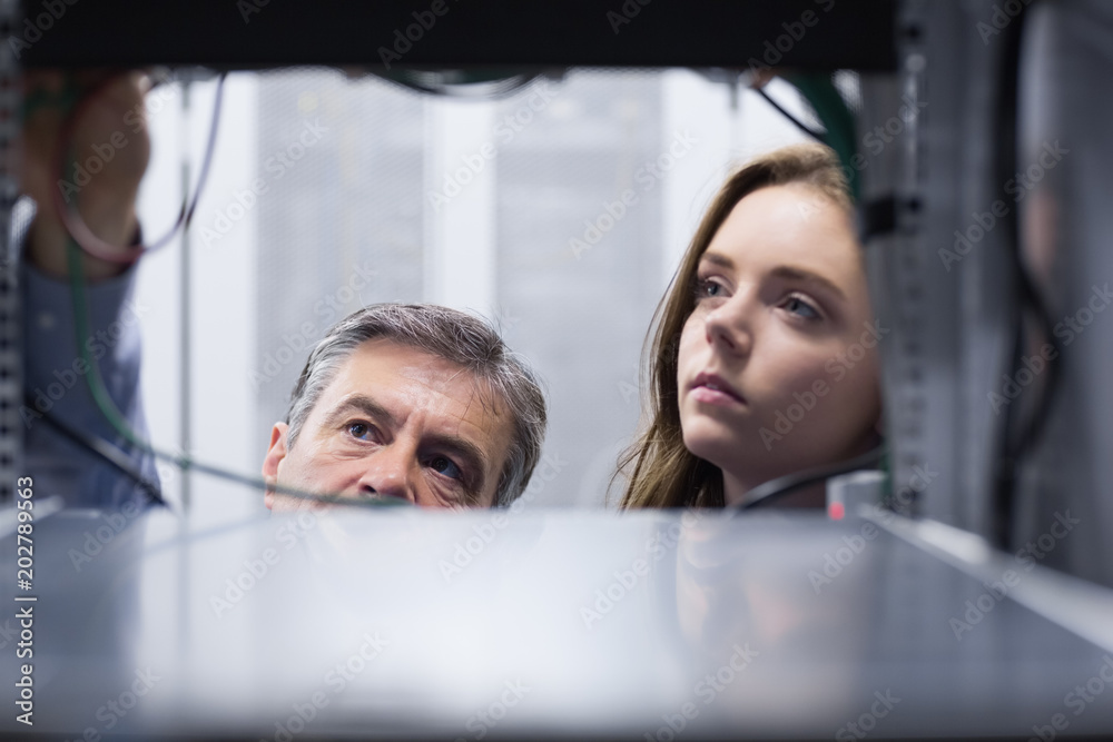 Poster Technicians looking into empty server towers