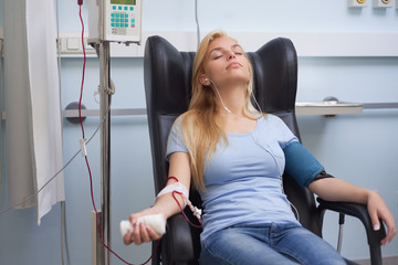 Patient receiving a transfusion while listening music