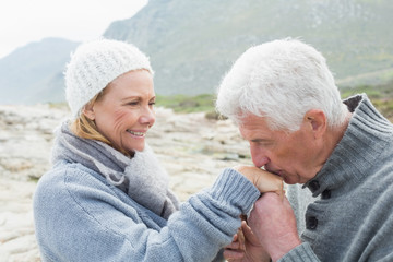 Senior man kissing happy womans hand