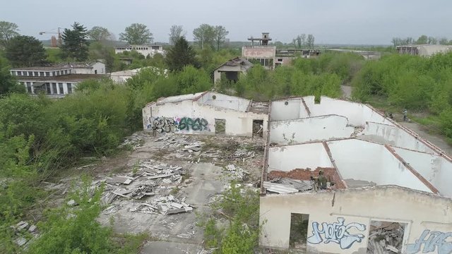 Aerial view on fully equipped soldiers and ruined buildings during military attack
