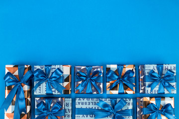 Gift boxes composition on blue background. Flat lay text space.