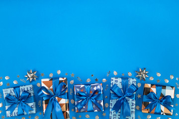 Gift boxes composition on blue background. Flat lay text space.