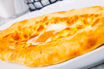 Ajarian khachapuri on white plate