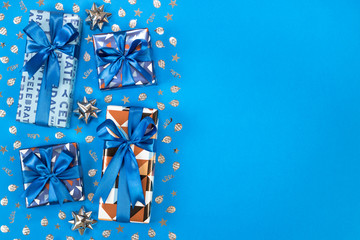 Gift boxes composition on blue background. Flat lay text space.