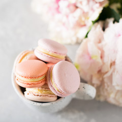 Spring mood still life with macaroons in cup and flowers