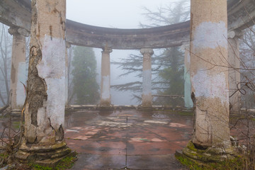 Rotunda of the abandoned building of the former restaurant on the top of Mount Akhun in dense fog, Sochi, Russia
