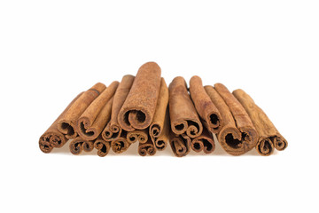 a lot of cinnamon sticks scattered on a white background