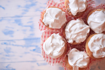 Cupcakes with white cream on a wooden background