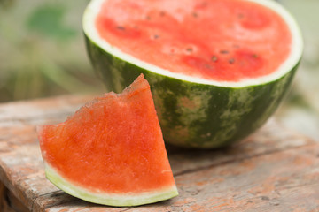 on an old stool a cut watermelon, a floor of a water-melon and a slice, a red pulp