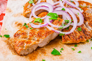 Fried minced beef with onion rings on pita bread. Armenian food. Kofta