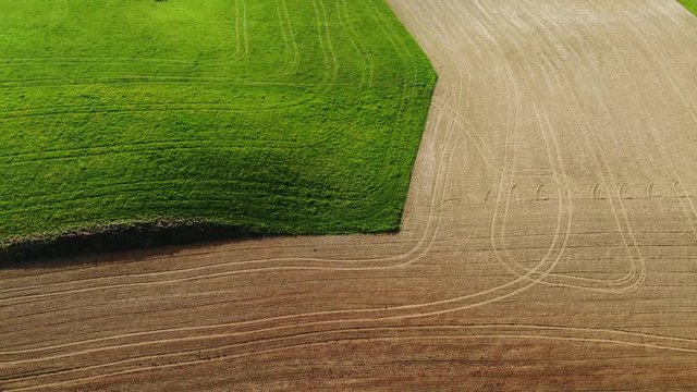 Vue a&eacute;rienne et graphique d'un champ cultiv&eacute; vert et d'un champ de terre labour&eacute;e ,avec des traces de tracteurs
