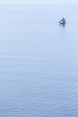 A calm blue sea with a single boat