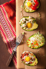 eggs baked in avocado with bacon, cheese, tomato and alfalfa sprouts