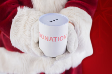 Obraz na płótnie Canvas Santa holds a can for donations against red background