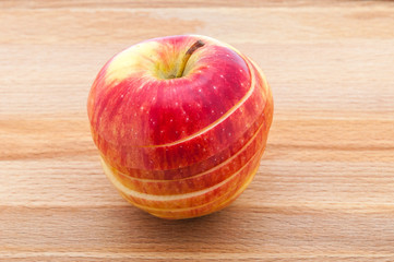 Red apple close-ups cut by mugs on a wooden cutting board