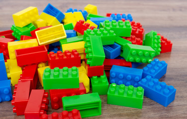 Colorful toy building blocks on wood background.