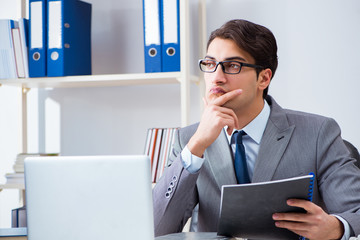 Young handsome businessman employee working in office at desk