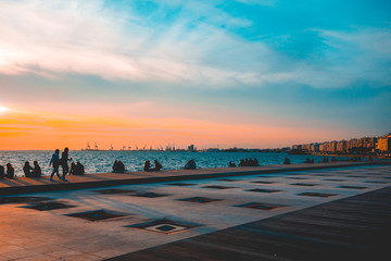 Group of people sitting enjoying an ocean sunset