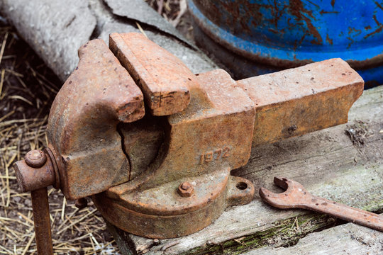 Old Broken Metal Vise With Rust On A Wooden Surface