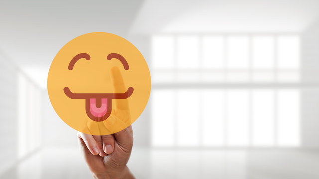 Finger wählt glücklichen Smiley mit ausgetreckter Zunge aus 