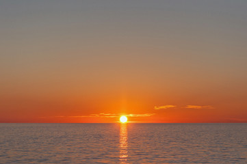 Obrazy  Zachód słońca nad morzem. Piękny zachód słońca nad płaskim horyzontem