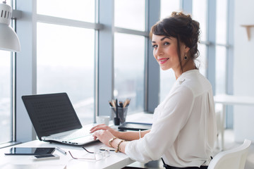 Woman working with laptop on the desk in office