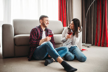 Love couple watches movie and drinks red wine
