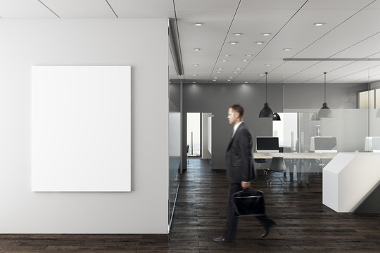 Businessman in modern office with empty wall