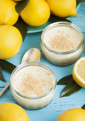 Glass jar with lemon cheesecake with fresh lemons