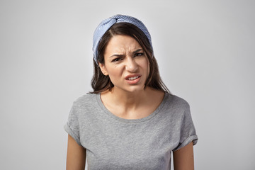 Negative human facial expressions. Horizontal shot of furious irritated young dark haired woman in stylish clothes staring at camera with distrustful angry look, suspicious of lie or betrayal