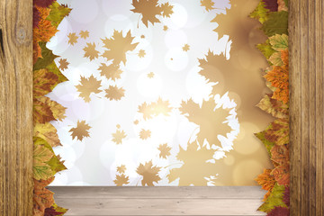 Naklejka na ściany i meble Autumn leaves pattern against overhead of wooden planks