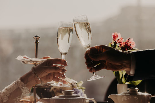 Man and woman celebrate wedding, have party with friends, clink glasses with sparkling wine or champagne. People, celebration and festive event concept