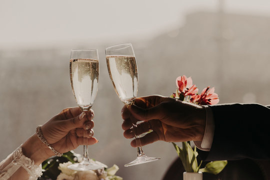 Young coupe in love have romantic date in luxurious restaurant, clink glasses with sparkling white wine or champagne, celebrate their engagement