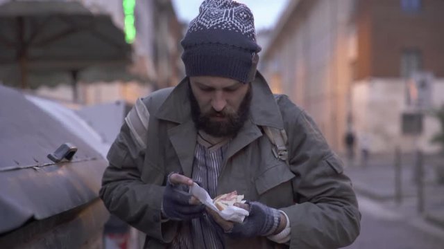 beggar finds a sandwich in the garbage-hunger, poverty ,despair